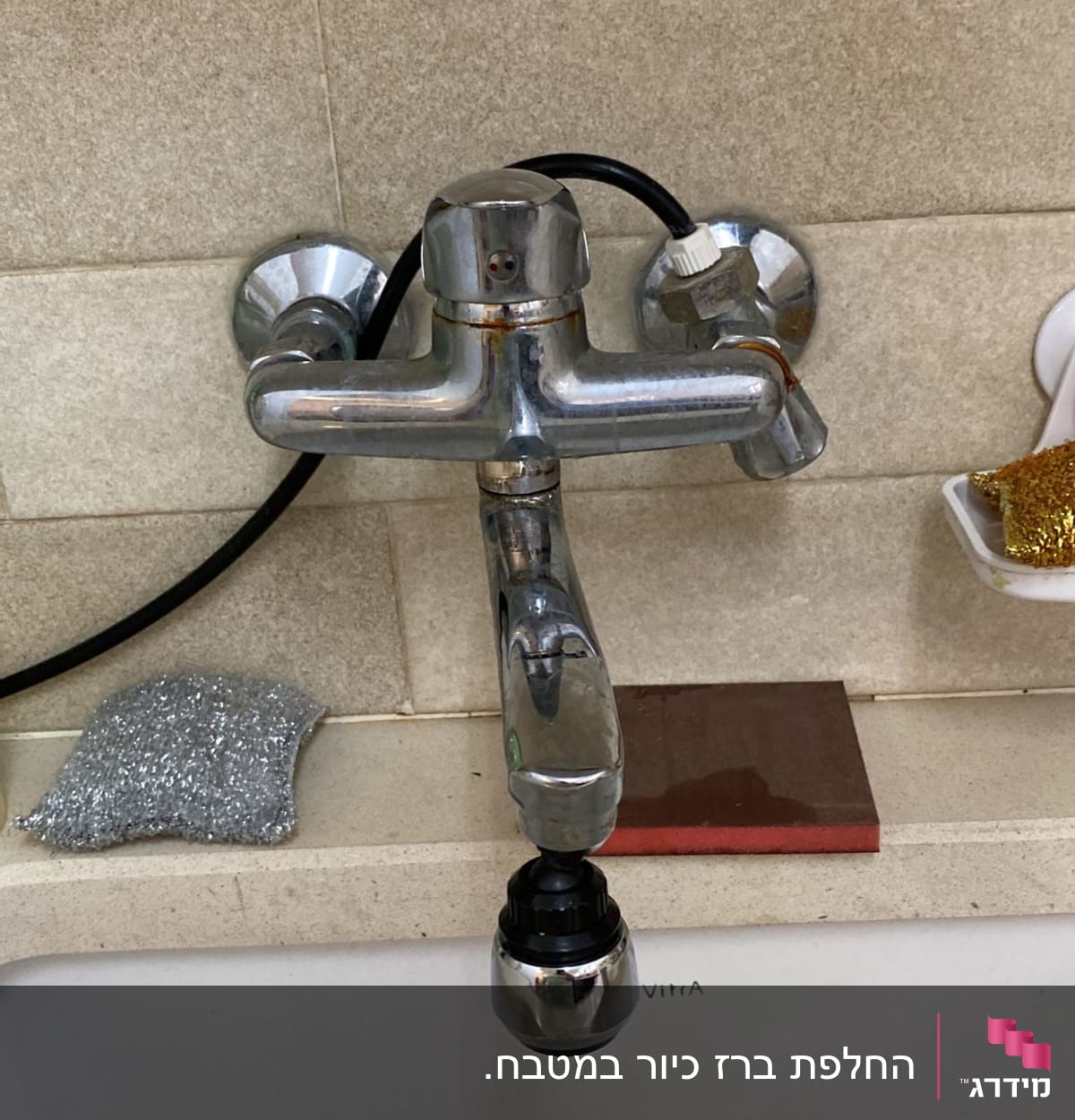 ברז מתכת עם צינור שחור מעל כיור לבן